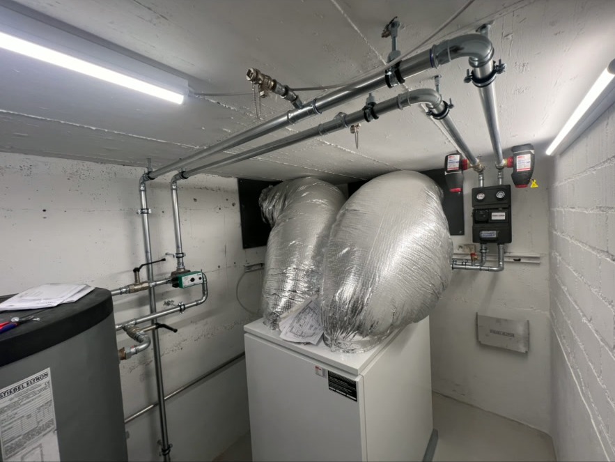 Technikraum – Wärmepumpe & Speicher – Kompletter Technikraum mit Stiebel Eltron Wärmepumpe, isoliertem Speicher, Rohrleitungen und Steuerungstechnik.