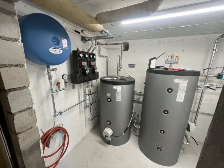 Heizraum – Speicher & Pumpengruppe – Heizraum mit Ausdehnungsgefäss, Pumpengruppe, Warmwasser- und Pufferspeicher. Komplette Installation mit Verrohrung und Manometern.