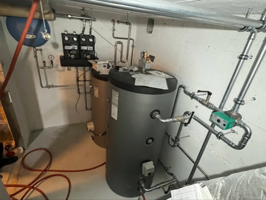 Pufferspeicher & Rohrleitungen – Pufferspeicher mit Wilo-Umwälzpumpe, Pumpengruppen und fachgerechter Verrohrung. Übersichtliche Anordnung im Technikraum.