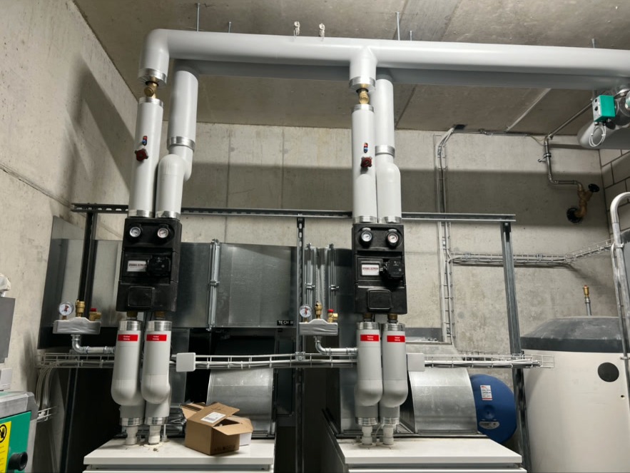 Doppel-Wärmepumpe mit Pumpengruppen – Zwei parallel geschaltete Wärmepumpen mit isolierten Steigleitungen, Pumpengruppen und Ausdehnungsgefäss. Leistungsstarke Anlage für Gewerbeliegenschaft.