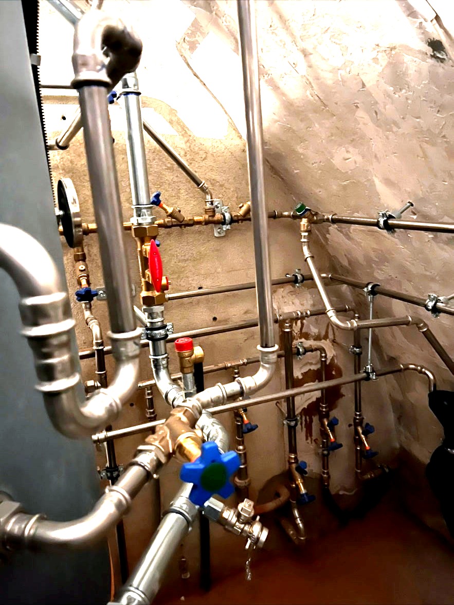 Speicheranschluss mit Pressfittings – Detailansicht der Rohrleitungsanschlüsse am Speicher mit Pressfittings, Absperrventilen und Kugelventilen in Edelstahl.