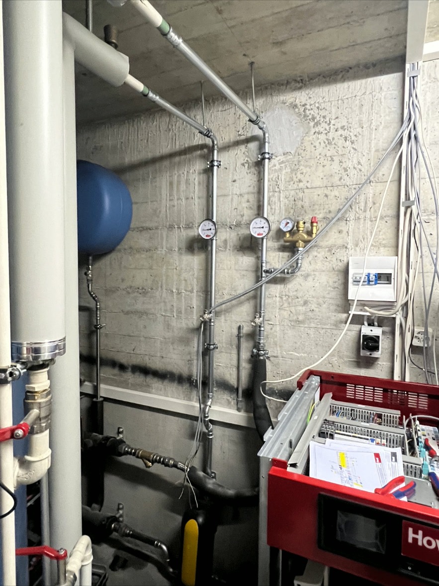 Technikraum mit Manometern & Ausdehnungsgefäss – Heizungsinstallation im Technikraum mit Manometern, Ausdehnungsgefäss, Sicherheitsgruppe und sauber geführten Rohrleitungen.