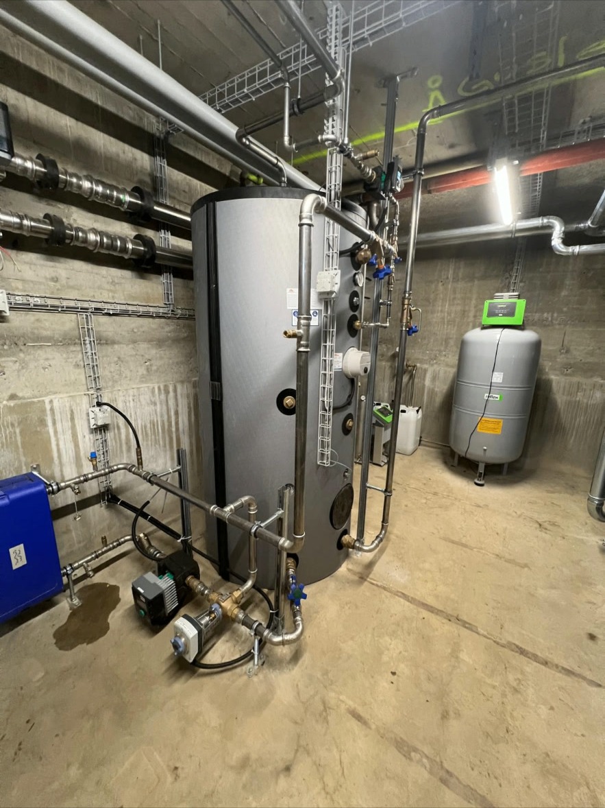 Pufferspeicher mit Pumpenstation – Grosser Pufferspeicher mit Pumpenstation, Armaturen und Druckausgleich für eine leistungsstarke Heizungsanlage.